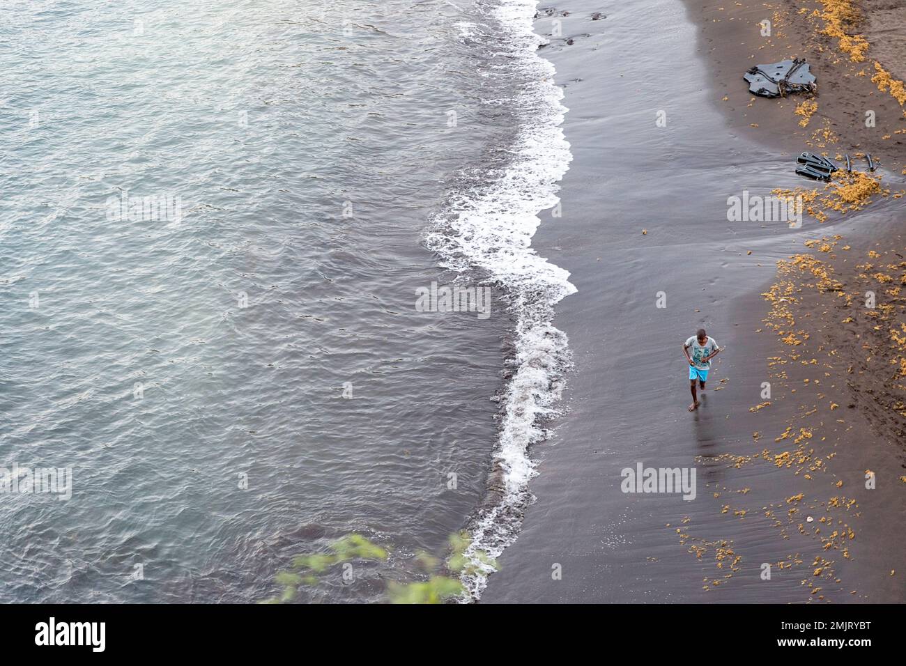 Local man running on the beach in Cidade Velha near Praia, Santiago island, Cabo verde, Cape verde Stock Photo