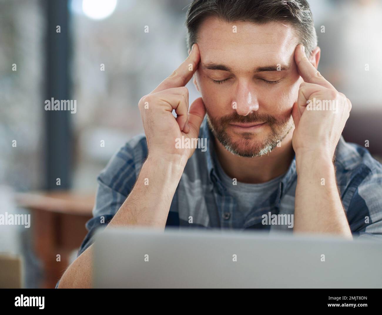 This day has turned into one big headache. a mature businessman looking stressed out at his office desk. Stock Photo