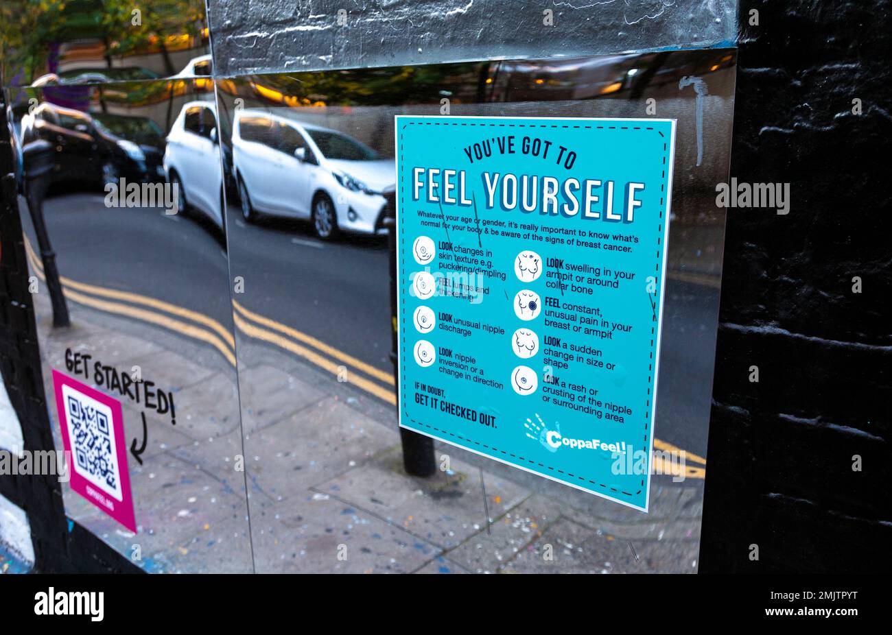 'Feel Yourself' poster with instructions on how to check for breaks cancer signs on a street in Shoreditch, London, UK Stock Photo