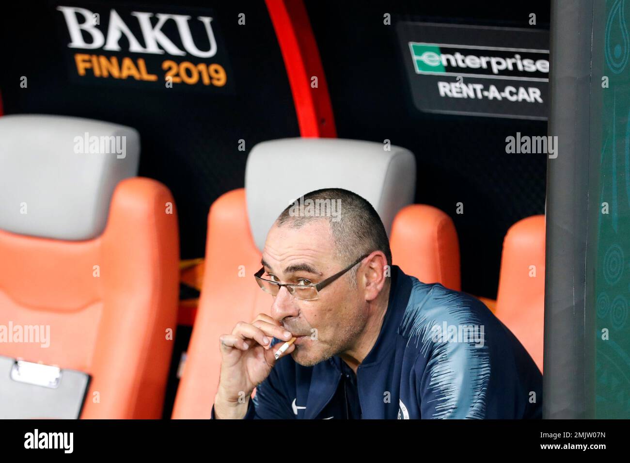 Chelsea head coach Maurizio Sarri smokes a cigarette on the bench after  winning the Europa League Final soccer match between Chelsea and Arsenal at  the Olympic stadium in Baku, Azerbaijan, Thursday, May