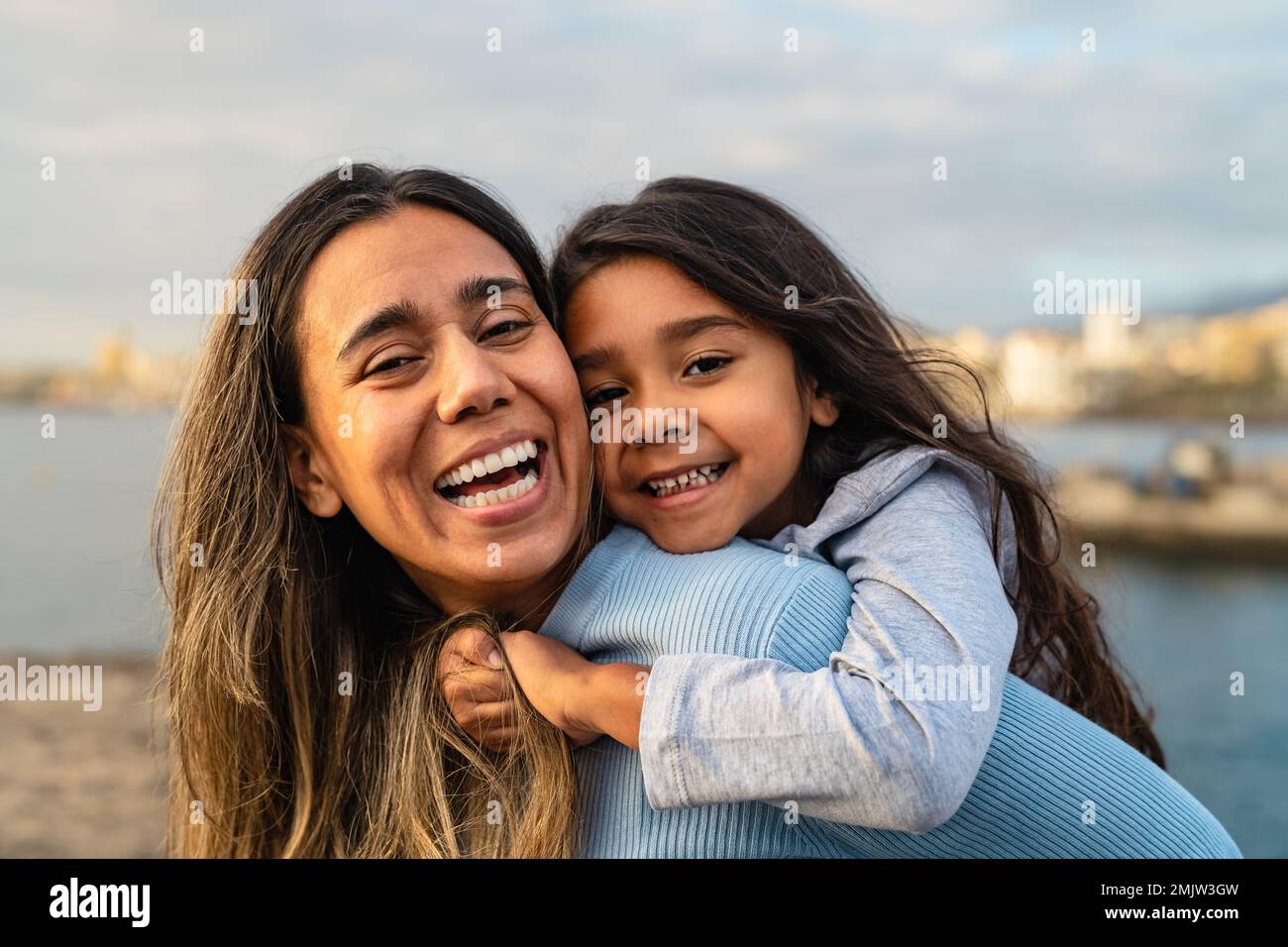 Happy Latin mother enjoying time with her child on the beach - Family and love concept Stock Photo