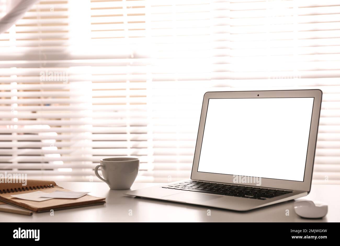 Laptop on desk near window in office. Comfortable workplace Stock Photo