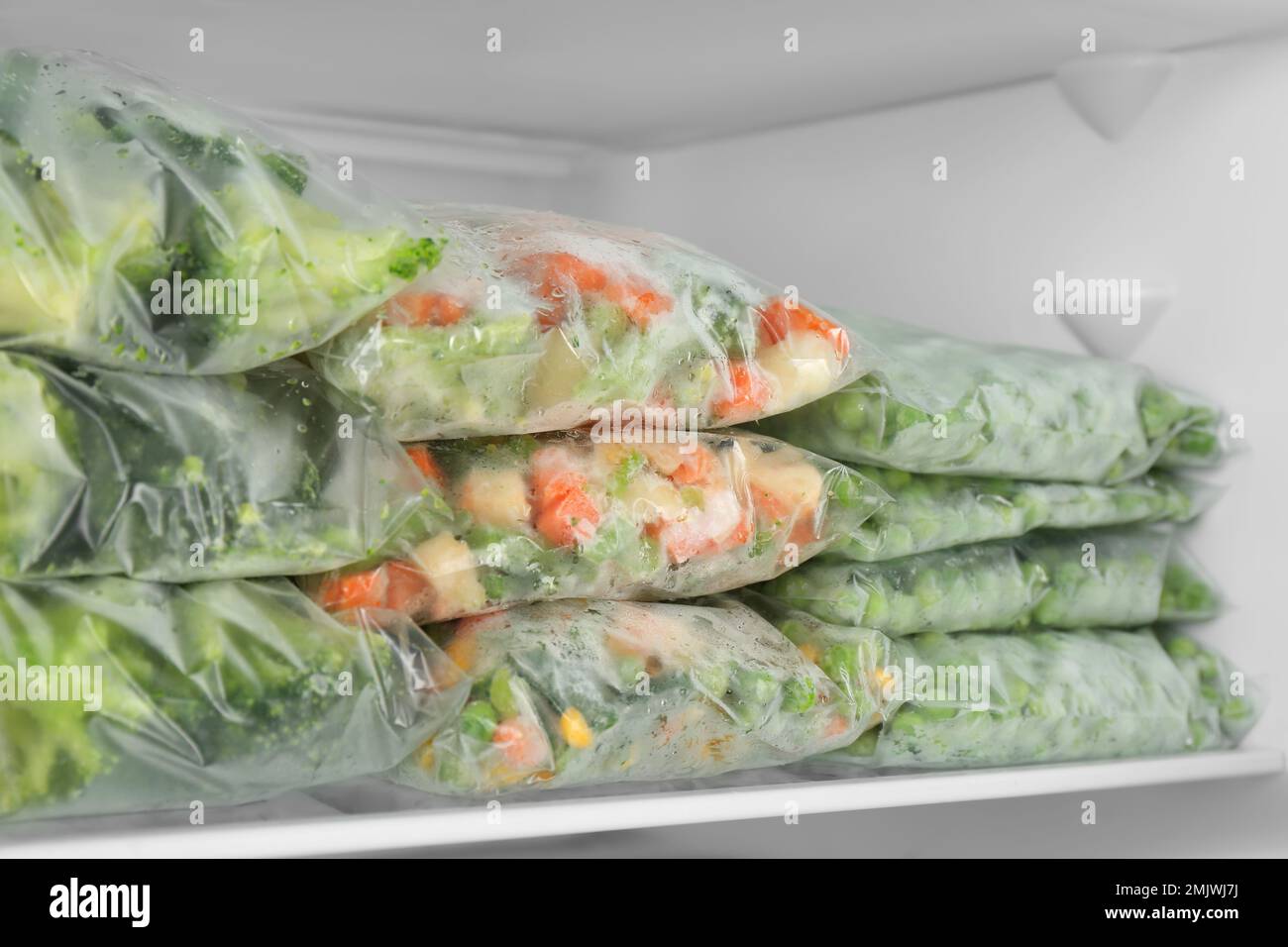 Plastic bags with different frozen vegetables in refrigerator Stock Photo Alamy