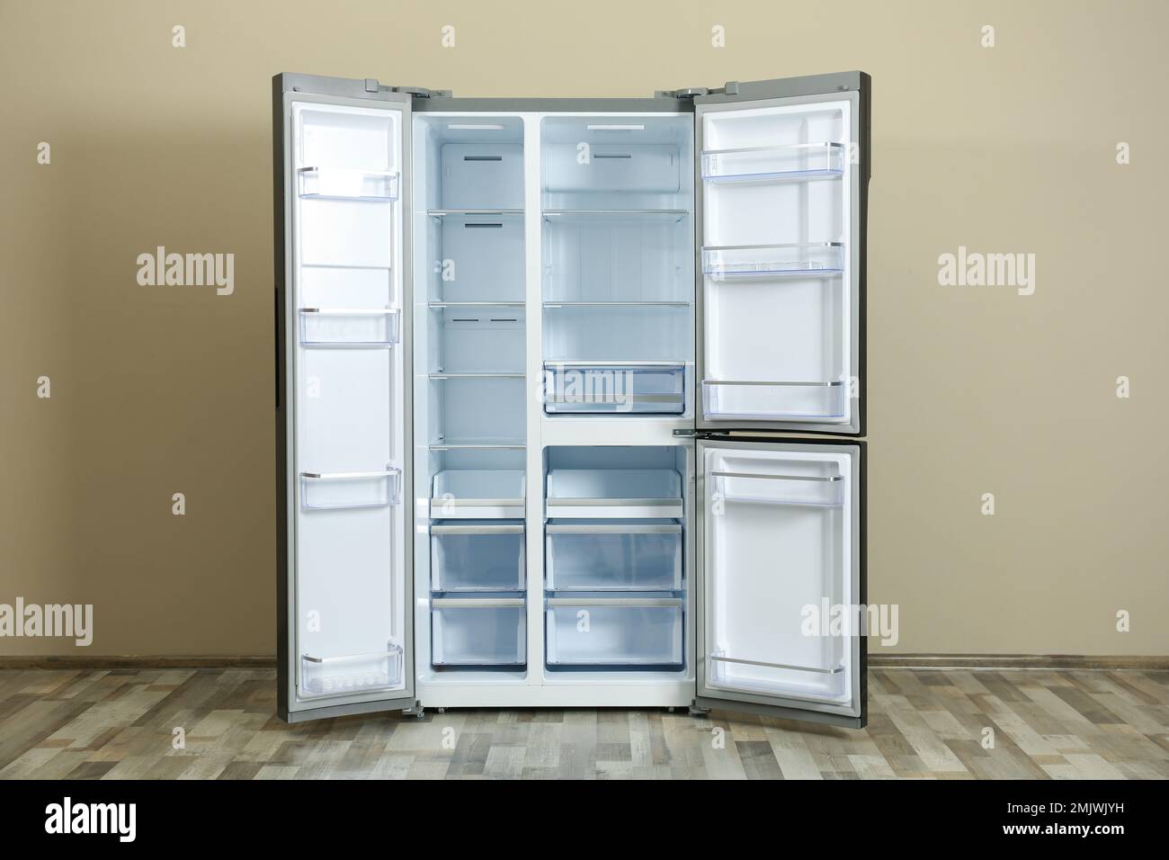 Modern empty refrigerator near beige wall. Home appliance Stock Photo