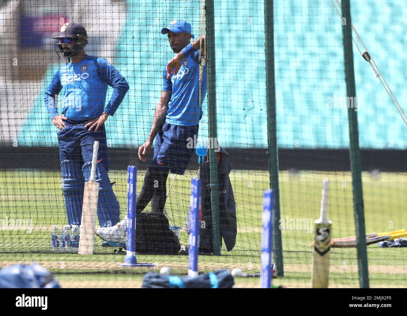 Indias Hardik Pandya, right, and Dinesh Karthik watch teammates bat in the nets during a training session at The Oval in London, Thursday, May 23, 2019