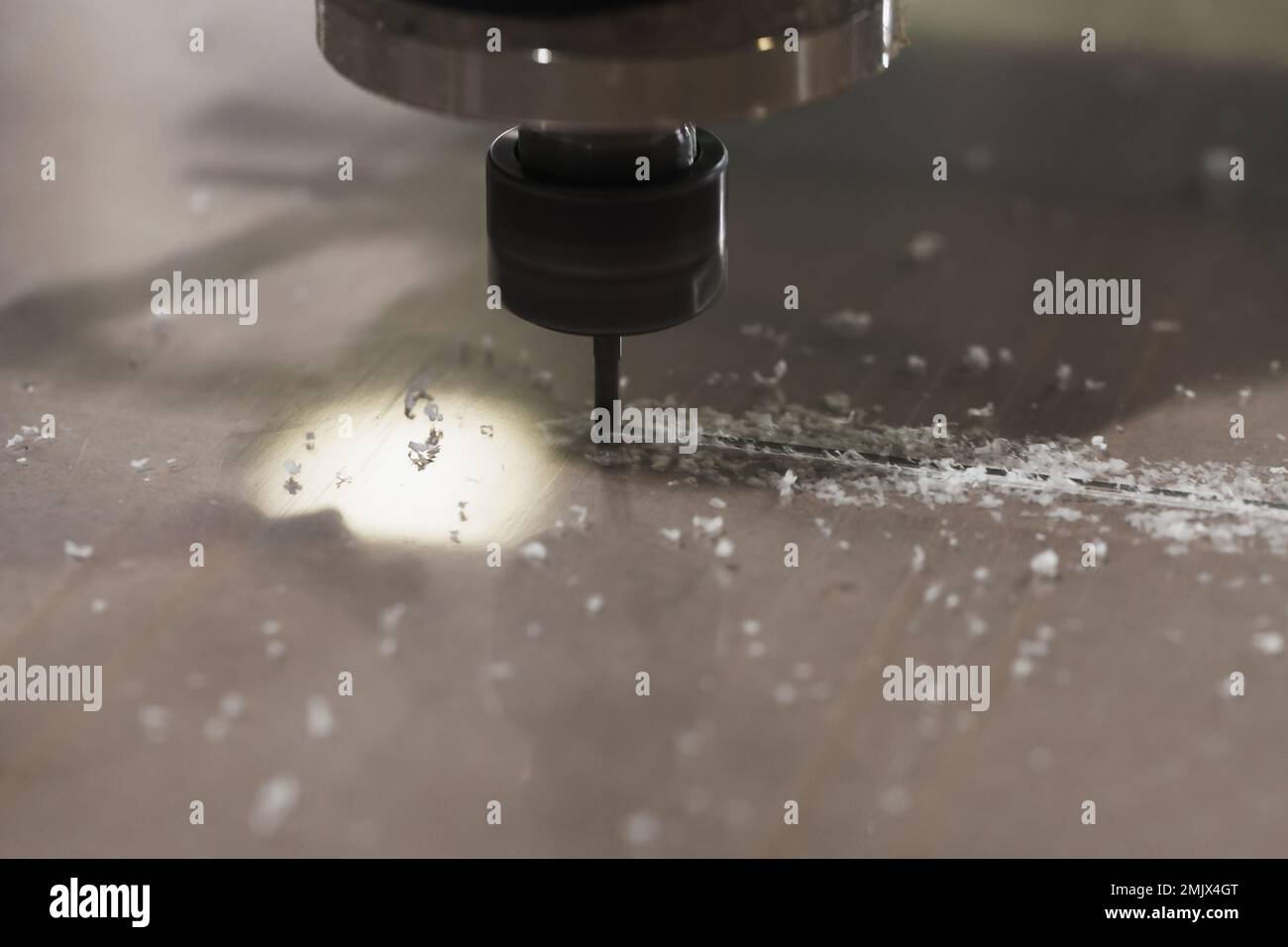 End mill processes a plastic sheet on a CNC milling machine, closeup