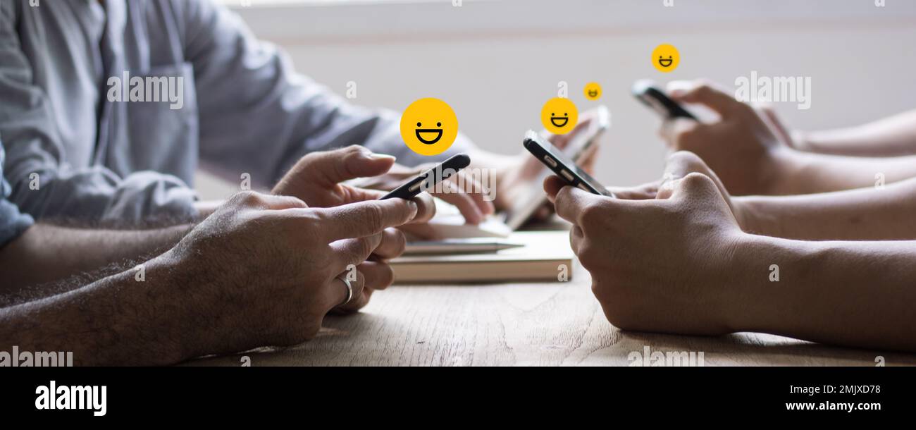 review rating and feedback, the best and excellent admire by reviewer, close up on customer hand pressing on smartphone screen with gold emoji faces Stock Photo