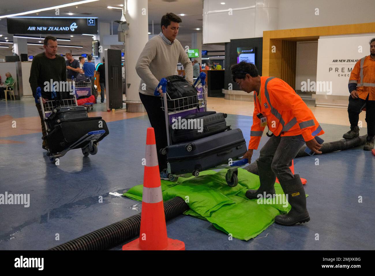 Auckland. 28th Jan, 2023. A staff member helps a passenger while