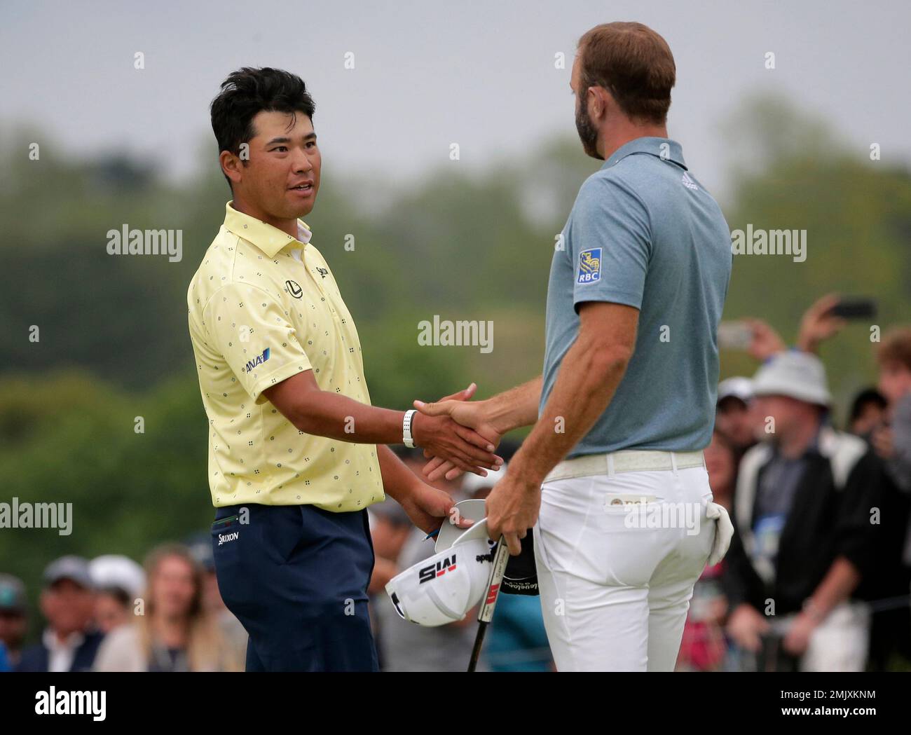 Hideki Matsuyama of Japan shakes hands with Dustin Johnson after