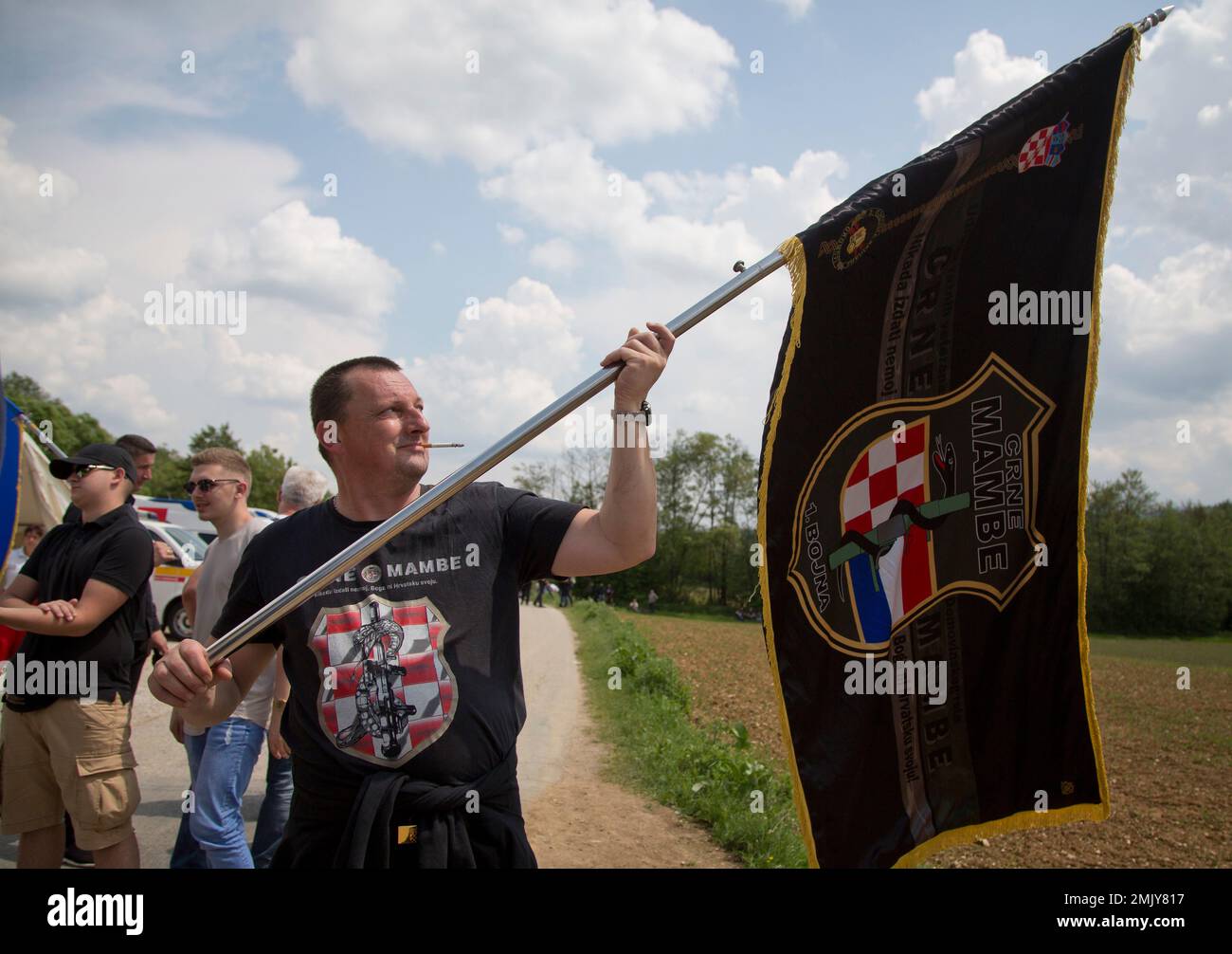 FILE - In this Saturday, May 12, 2018 file photo, a Croatian war veteran  hold his unit's flag which he was prevented to bring to a commemoration  ceremony, in Bleiburg, Austria. Thousands