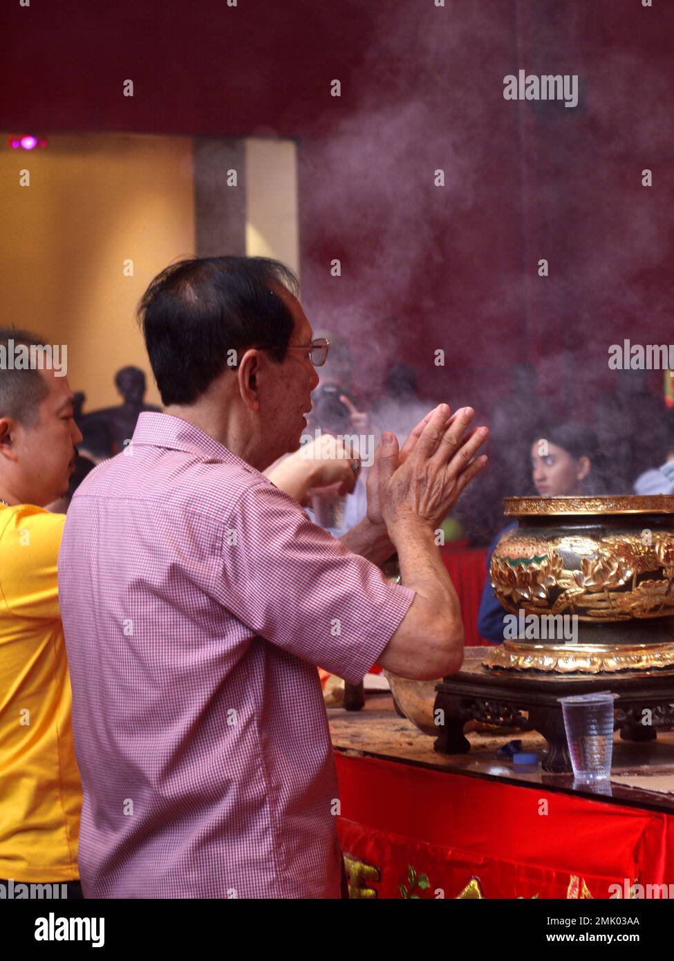 Chinese people praying in a temple during the Chinese New Year celebration. Stock Photo
