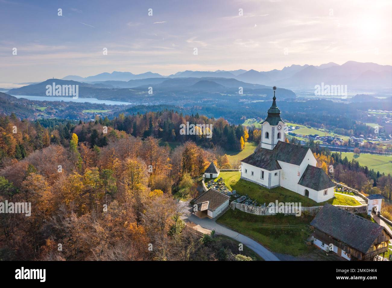 Sternberg church and idyllic graveyard in Wernberg, Carinthia, Austria during autumn with a view to Lake Wörthersee in the background. Stock Photo