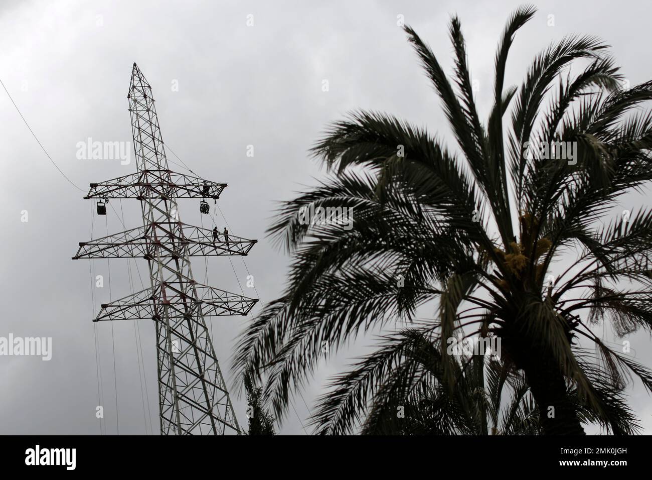 Workers install highvoltage power lines during a protest against the