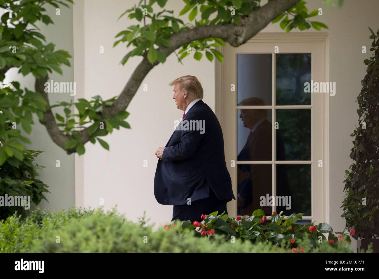 President Donald Trump walks out of the Oval Office of the White House ...