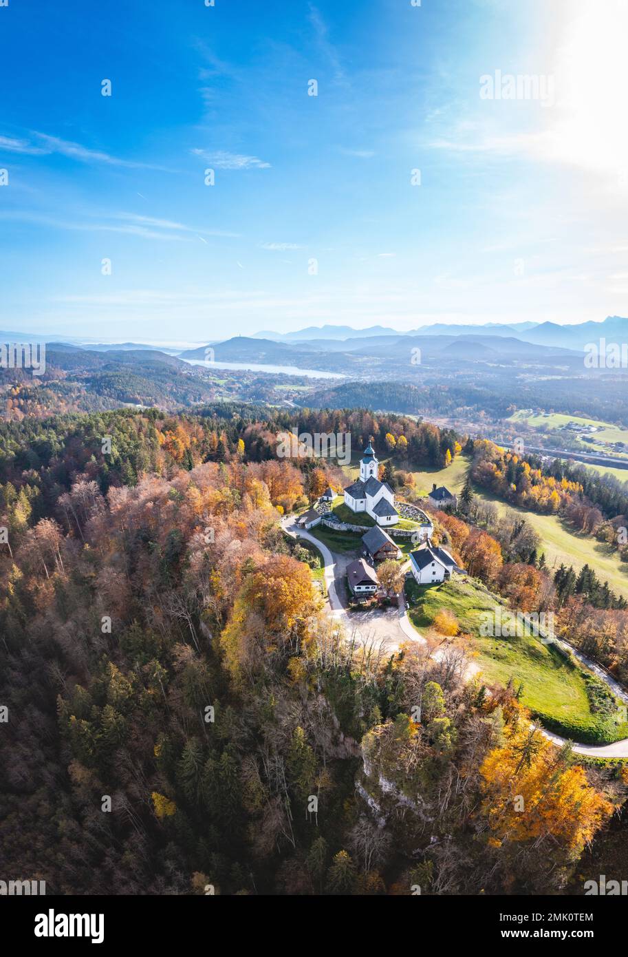 Sternberg church and idyllic graveyard in Wernberg, Carinthia, Austria during autumn with a view to Lake Wörthersee in the background. Stock Photo