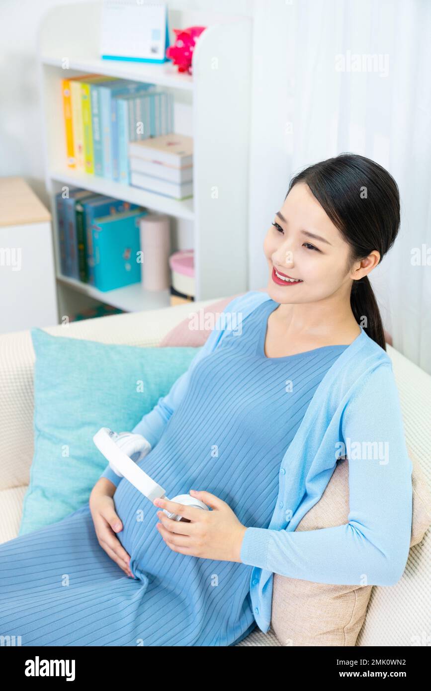 Pregnant women put headphones on the belly Stock Photo Alamy