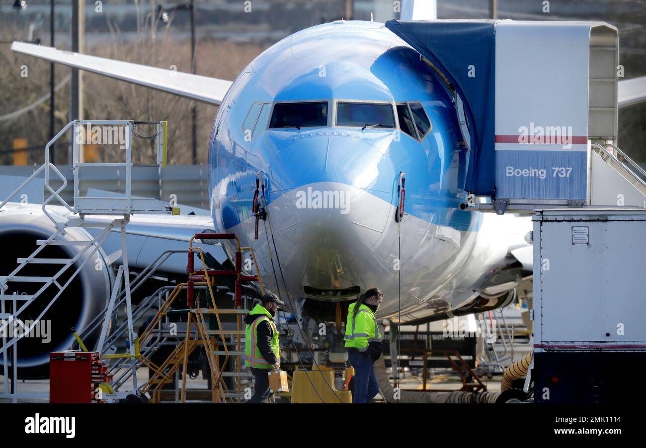FILE In this March 13, 2019, file photo, workers walk past a Boeing