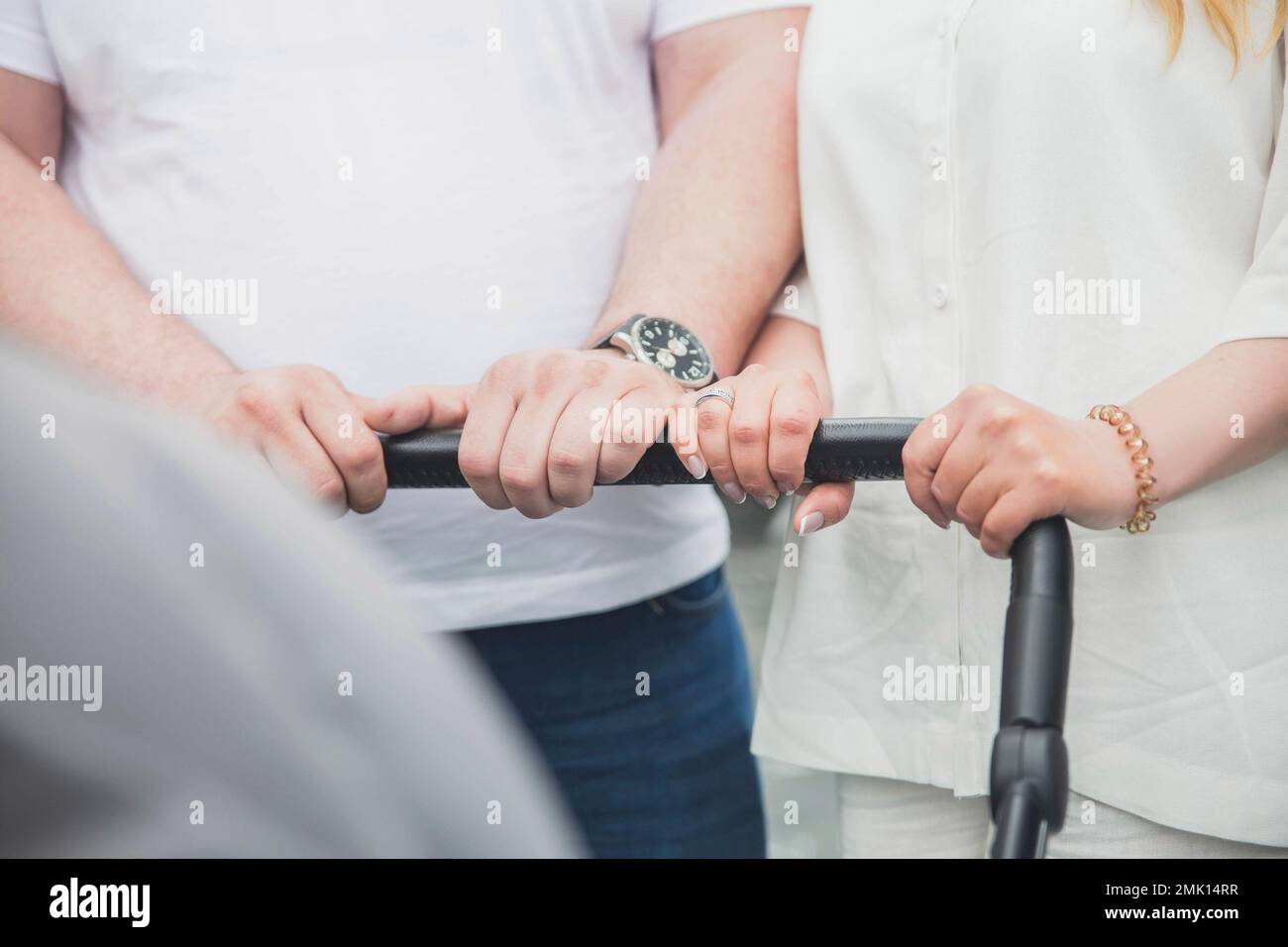 married couple is driving a baby stroller Stock Photo