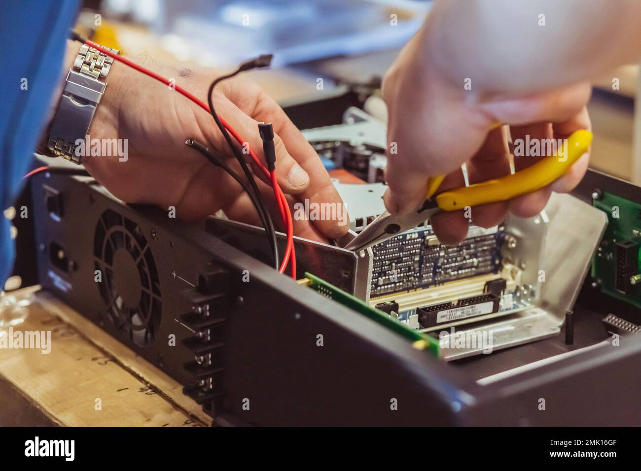 The worker assembles the amplifier to the speaker system Stock Photo