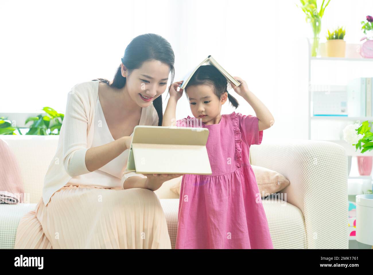 The little girl and her mother read a book together Stock Photo