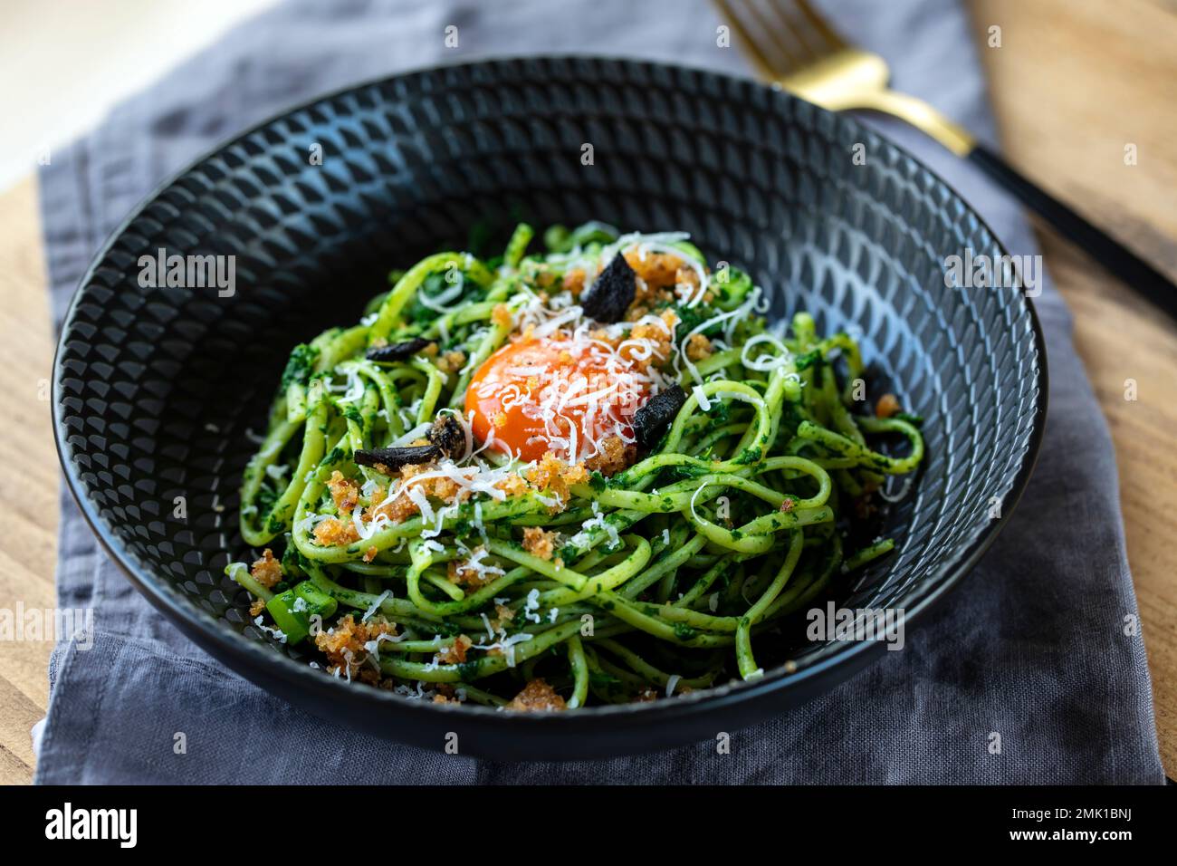 Linguine pasta with black garlic, spinach sauce and egg yolk Stock