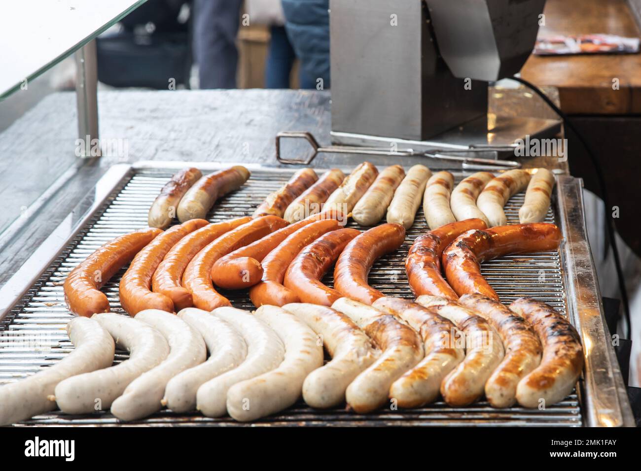 Variety of German sausages on the cooking grate of a hotdog stall