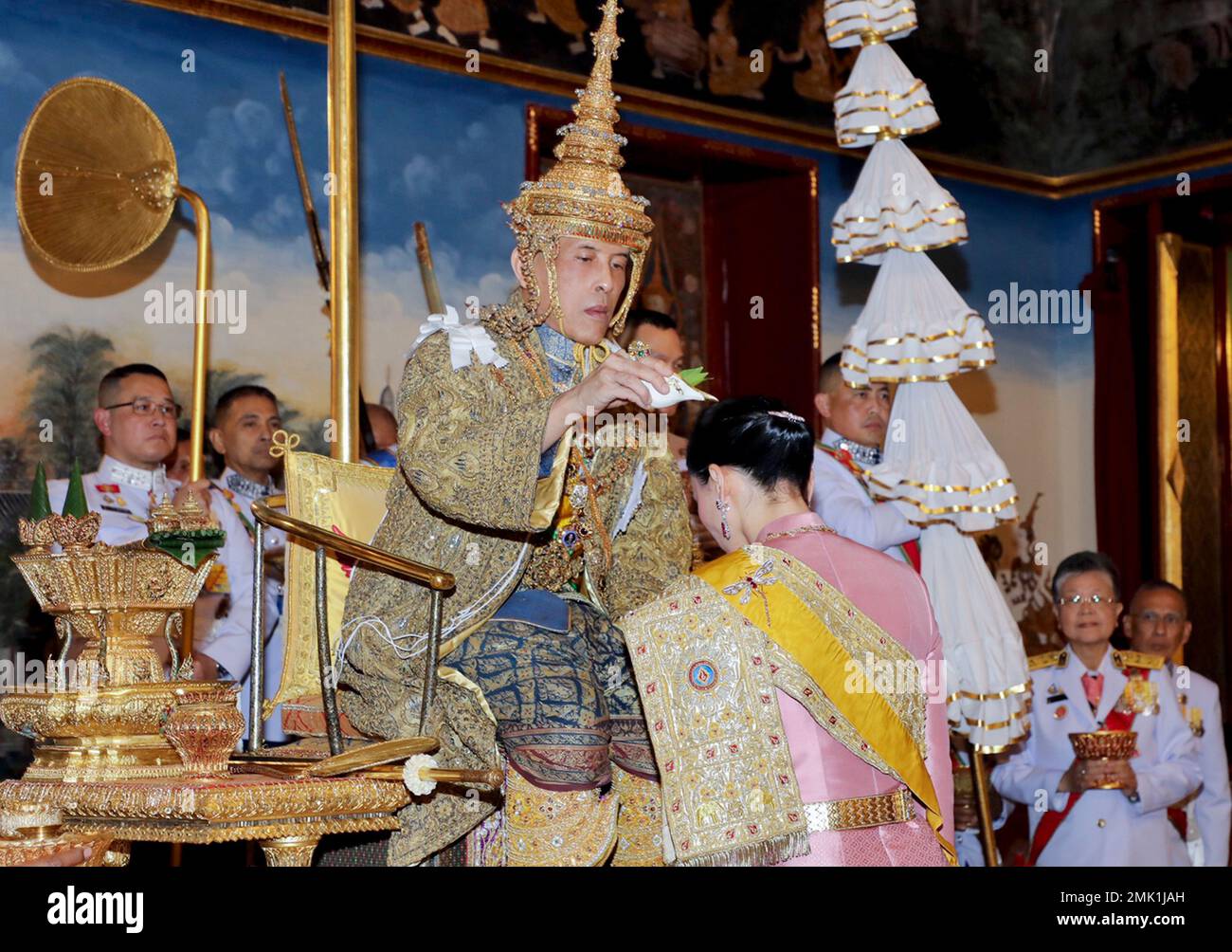 In this photo released by Bureau of the Royal Household, Thailand's King  Maha Vajiralongkorn sits on the throne and performs rituals as Queen  Suthida pay homage at the Grand Palace, Saturday, May