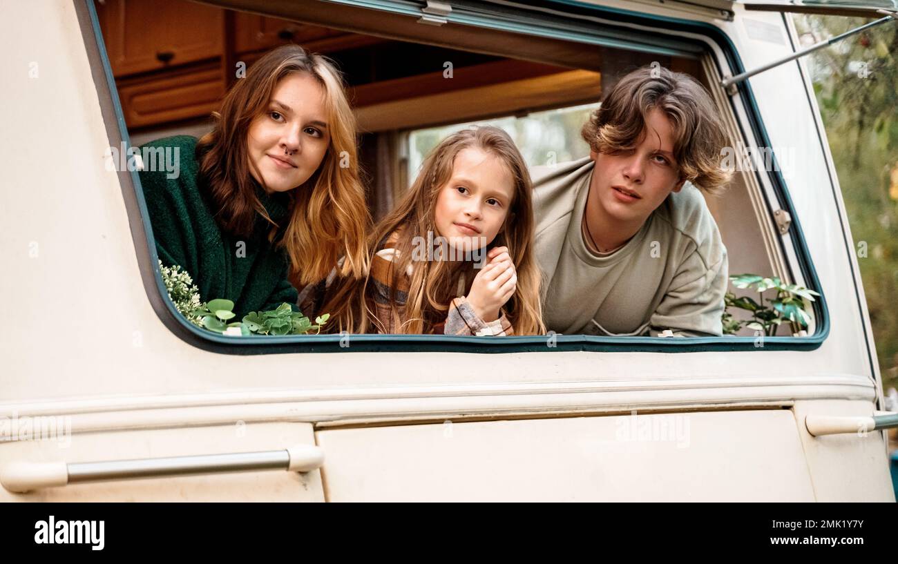 Children,family,brother sister traveling in camper,house on wheels. Trailer motor home.Looking in window. Funny road travel.Campsite van overnight.Wan Stock Photo