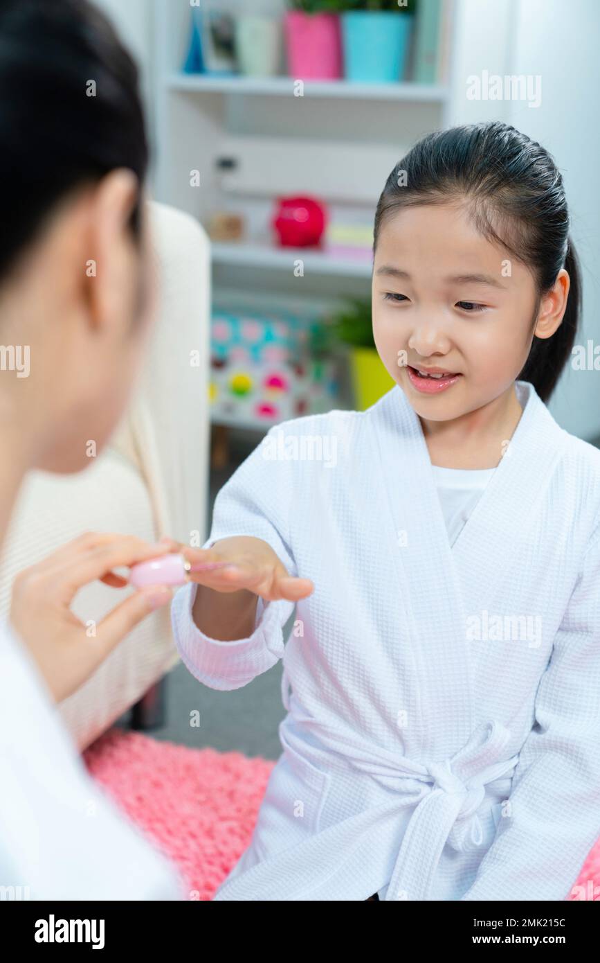 Mother to daughter wear nail polish Stock Photo Alamy