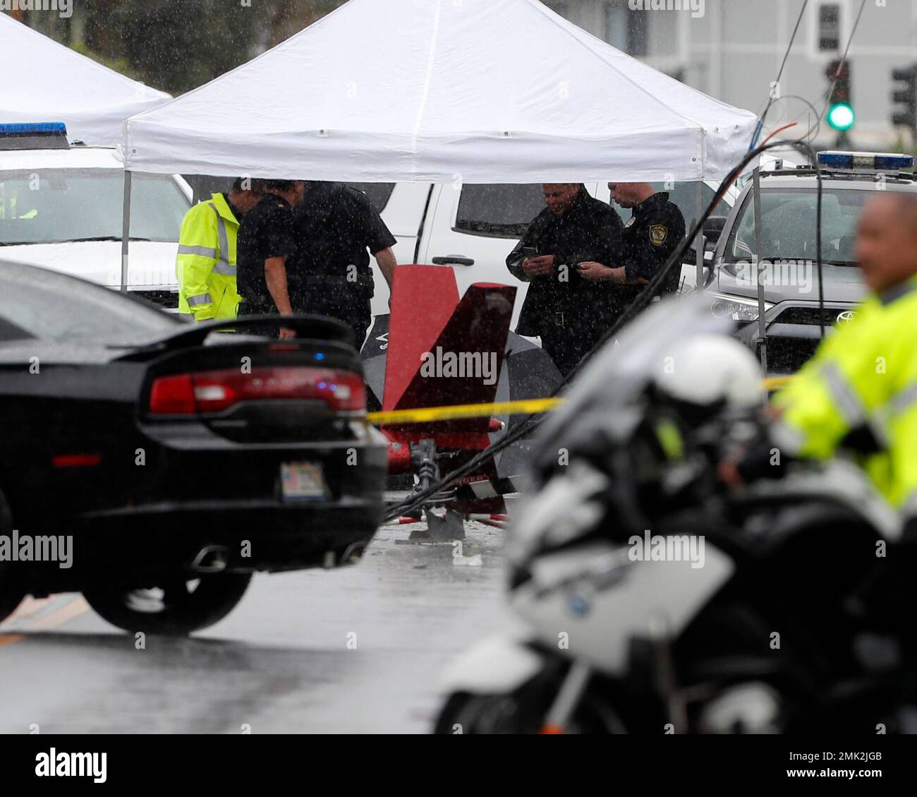 Investigators stand around the wreckage of a helicopter, Monday, April