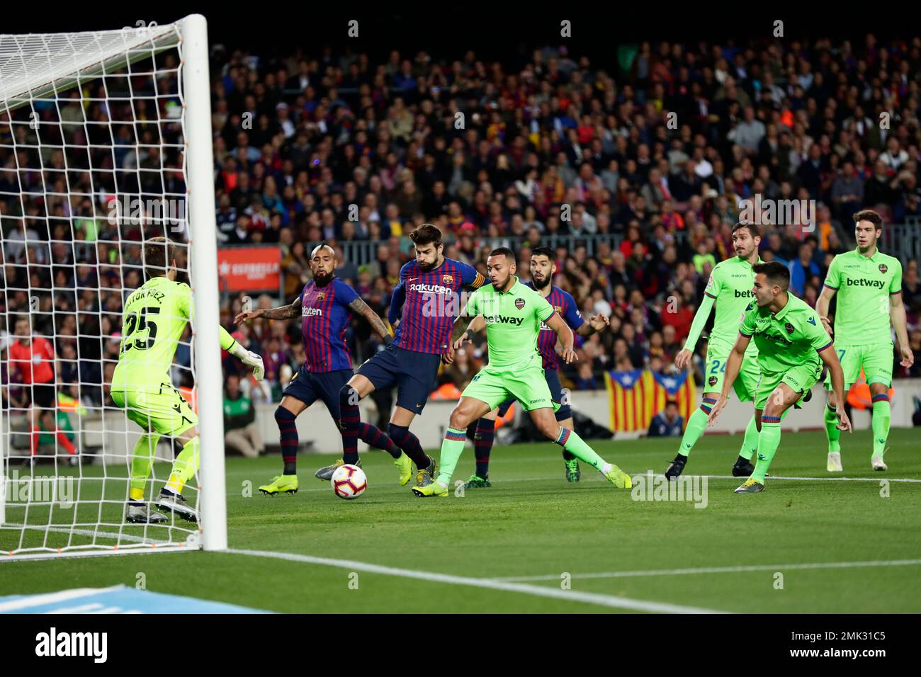 Barcelona defender Gerard Pique, third left, attempts a shot at goal in front of Levante's goalkeeper Aitor Fernandez, left, during a Spanish La Liga soccer match between FC Barcelona and Levante at the Camp Nou stadium in Barcelona, Spain, Saturday, April 27, 2019. (AP Photo/Manu Fernandez) Stock Photo