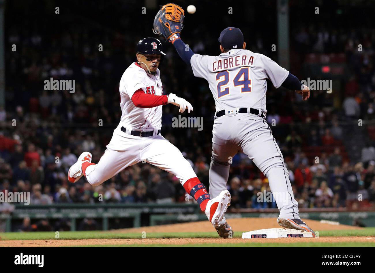 Boston Red Sox's Mookie Betts, left, legs out a single as Detroit Tigers first  baseman Miguel Cabrera (24) catches the throw during the seventh inning of  a baseball game at Fenway Park,, image size:1300x949