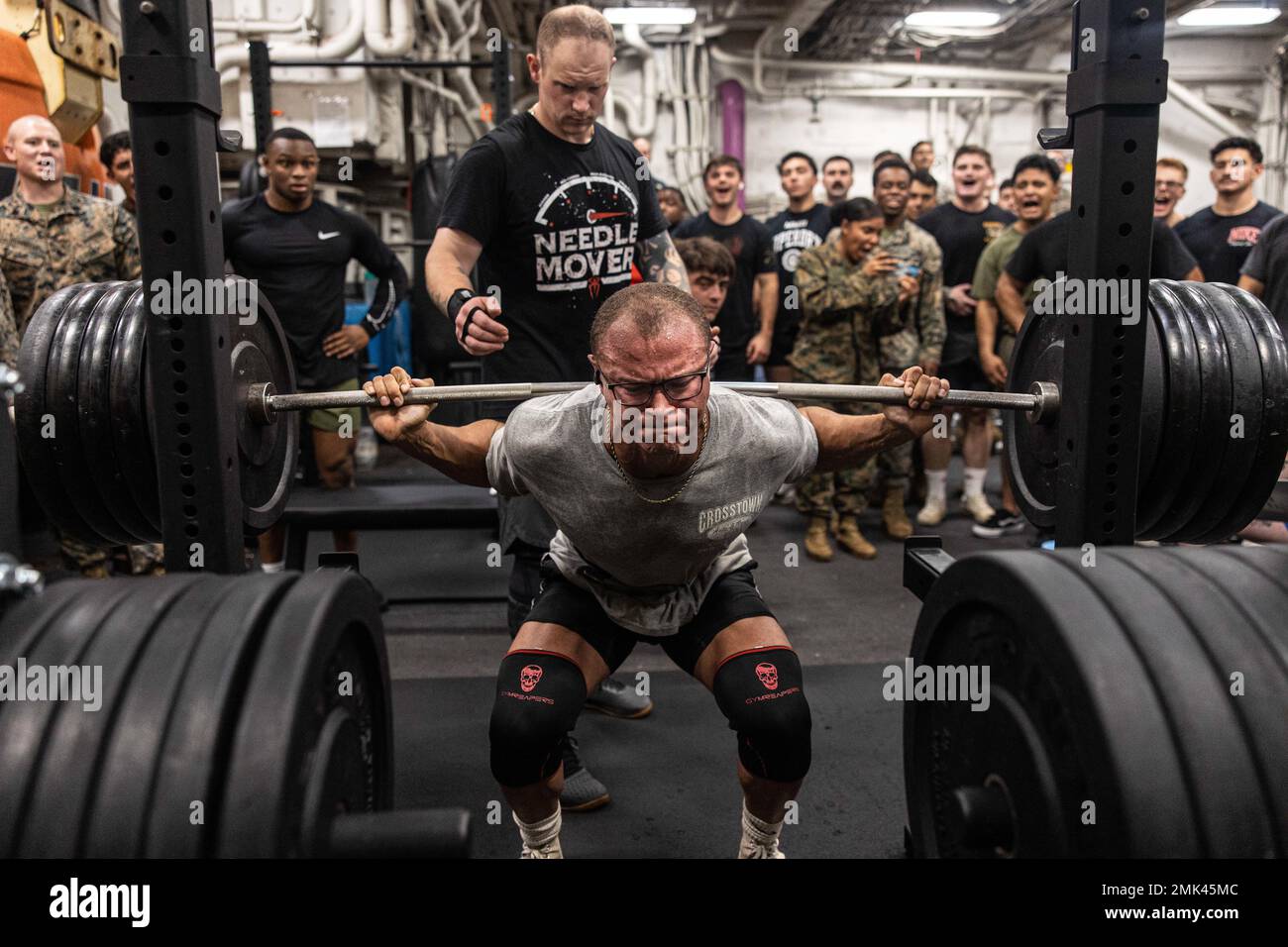 U.S. Marine Corps Lance Cpl. Justin Rigling, a field artillery fire controller with Battalion Landing Team 2/5, 31st Marine Expeditionary Unit, squats during a weightlifting meet aboard USS New Orleans (LPD 18) in the Sea of Japan, Sept. 4, 2022. The 1000 Pound Club is a weightlifting event where participants must lift a cumulative one thousand pounds in squat, bench, and deadlift. The 31st MEU is operating aboard ships of the Tripoli Amphibious Ready Group in the 7th fleet area of operations to enhance interoperability with allies and partners and serve as a ready response force to defend pea Stock Photo