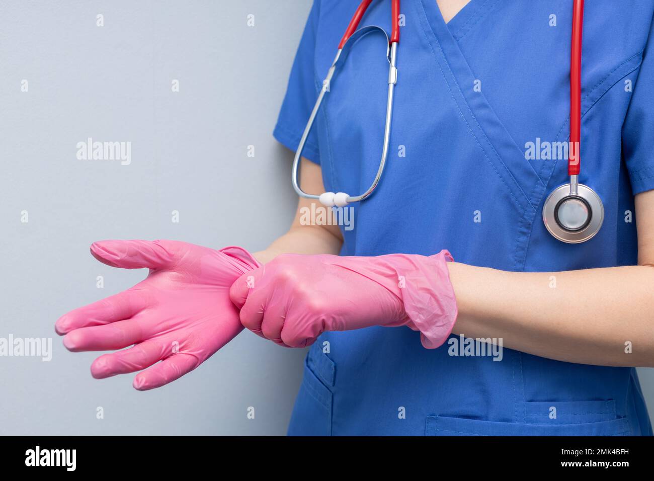 doctor in the hospital puts on a glove. doctor wear gloves. doctor puts on rubber gloves. doctor examining a patient. Stock Photo