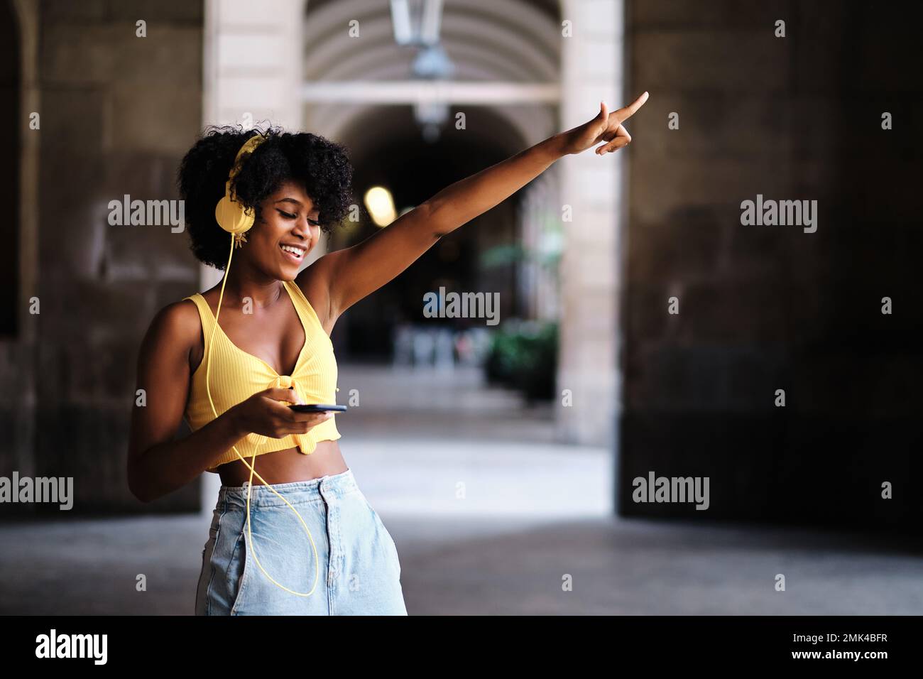 Woman with eyes closed dancing relaxed while listening music with headphones outdoors Stock