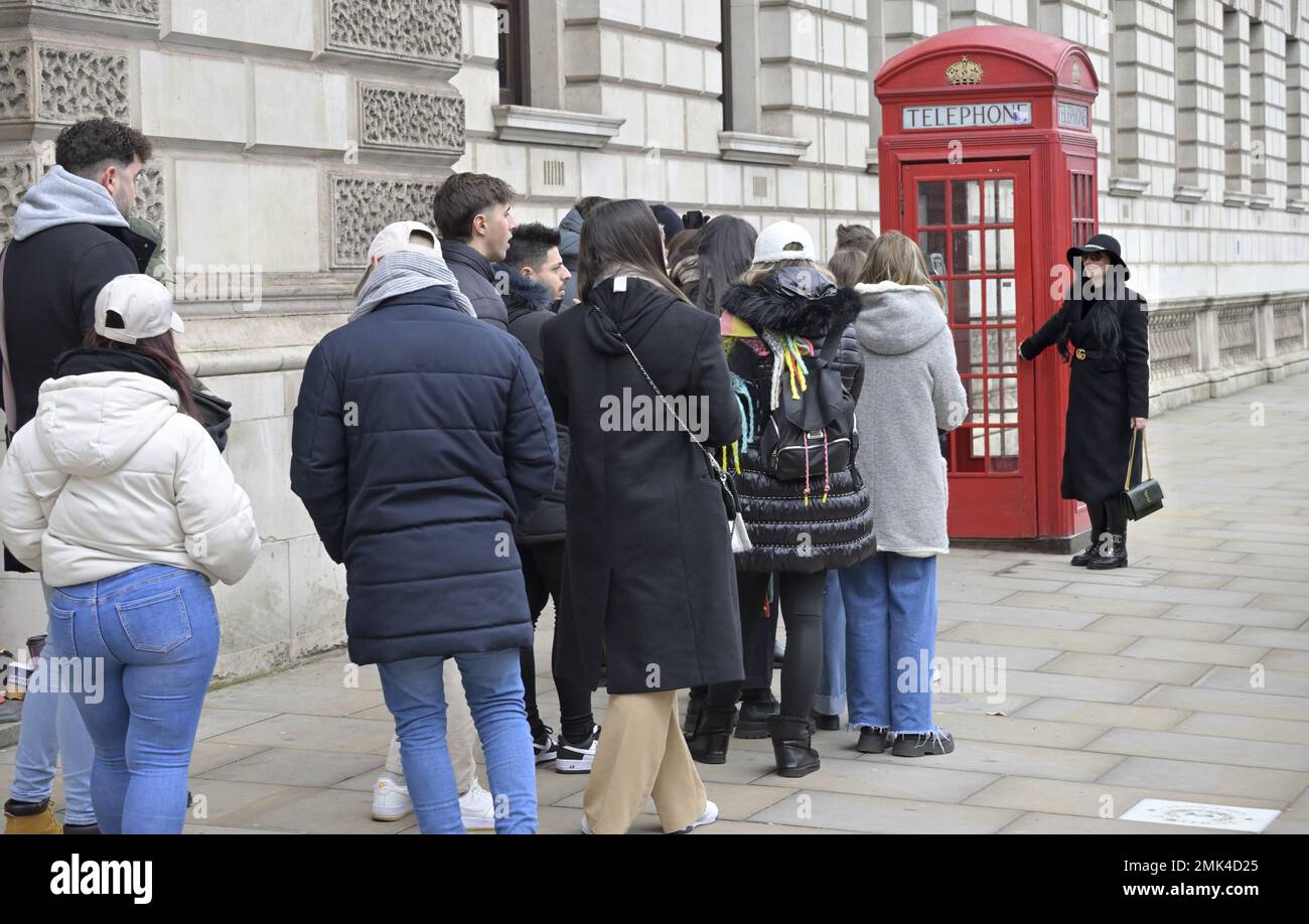 London, England, UK. Tourists queueing to have their photo taken by one of the iconic red phoneboxes in Parliament Square, Westminster. Stock Photo