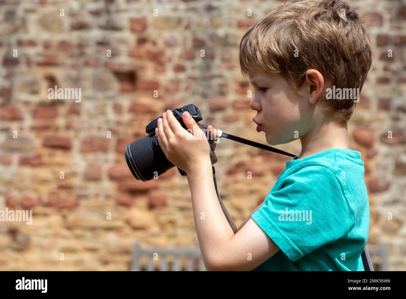 Five year old boy learning how to use a camera Stock Photo