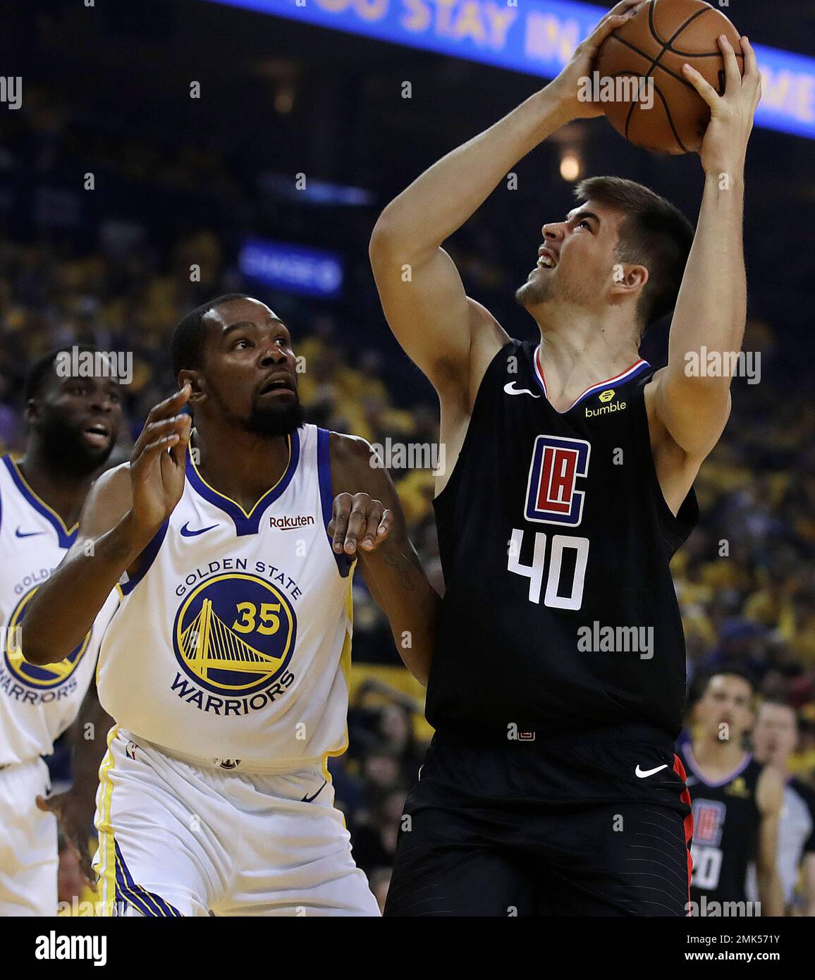 Los Angeles Clippers' Ivica Zubac, right, shoots against Golden State  Warriors' Kevin Durant (35) during the first half in Game 1 of a  first-round NBA basketball playoff series Saturday, April 13, 2019,