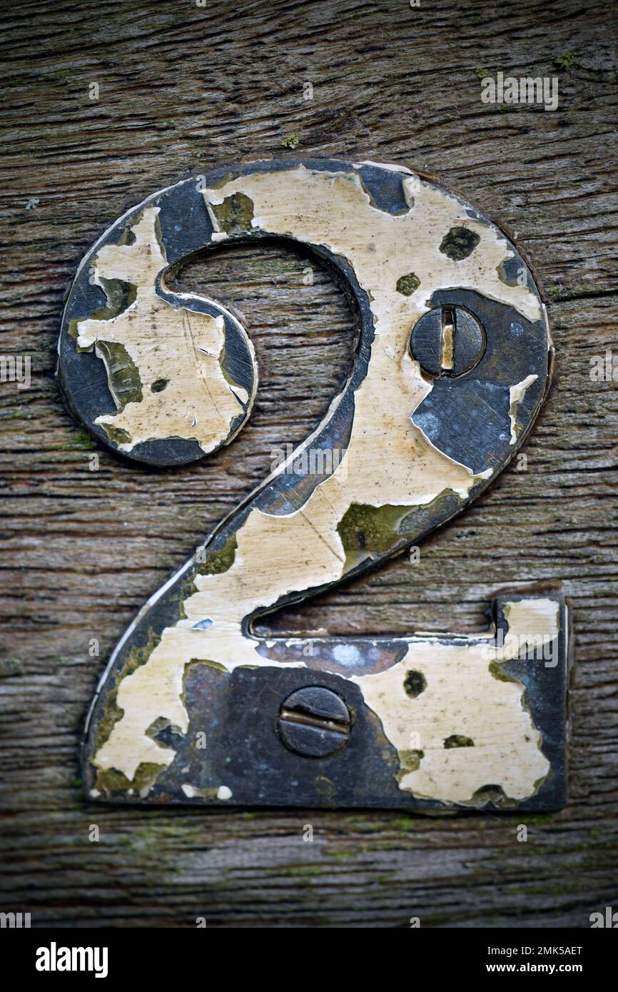 painted brass house number with flaking paint Stock Photo Alamy