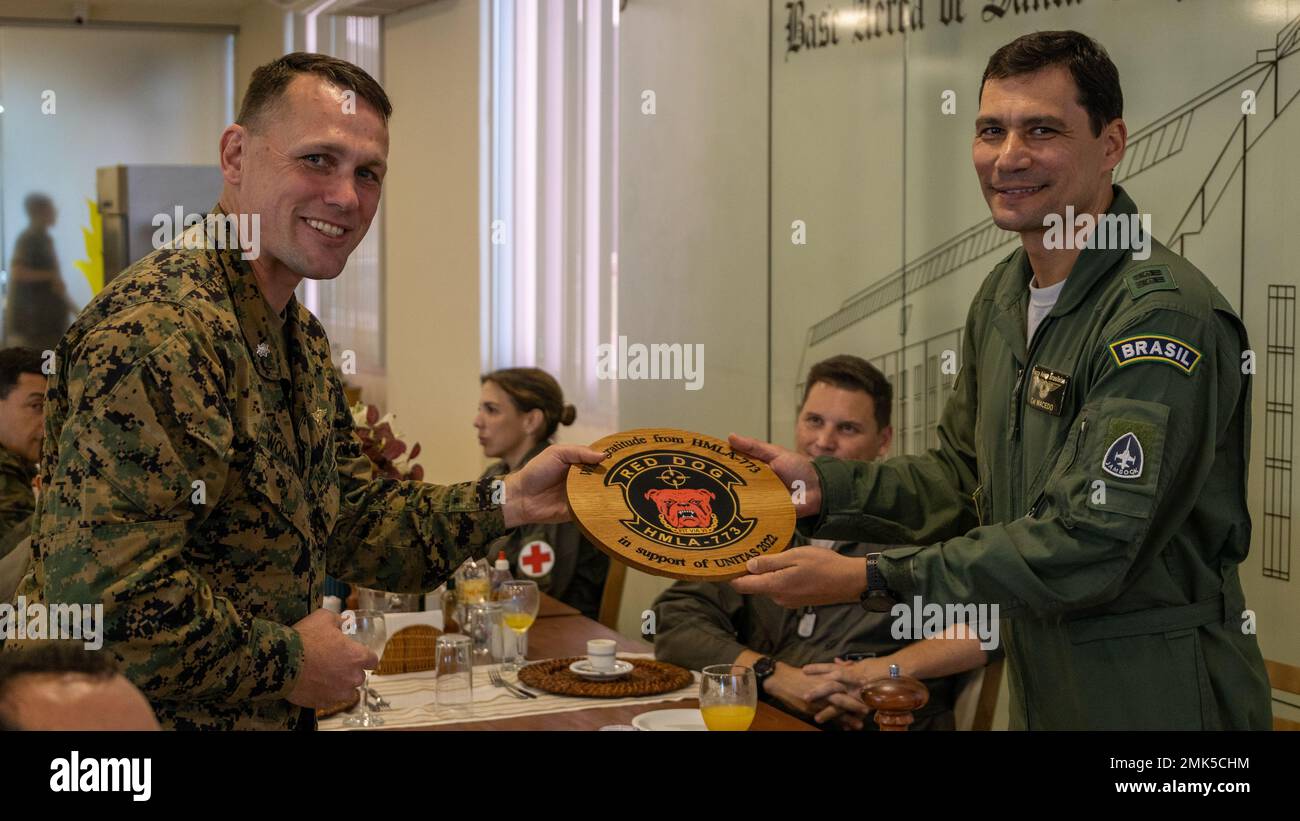 Lt. Col William C. Woodward, Commander of Marine Light Attack Helicopter Squadron - 773, left, presents a gift to Capitao de mar e guerra (Brazilian Marine Corps Coronel) Marcos de Oliveria Macedo, Operations Group Commander in Santa Cruz Air Force Base, during exercise UNITAS LXIII, Rio De Janeiro, Sept. 5, 2022. Lt. Col Woodward’s gift is an expression of gratitude to the Brazilian armed forces for providing support and integrating with the U.S. Marines during exercise UNITAS LXIII. UNITAS is the world’s longest-running annual multinational maritime exercise that focuses on enhancing interop Stock Photo