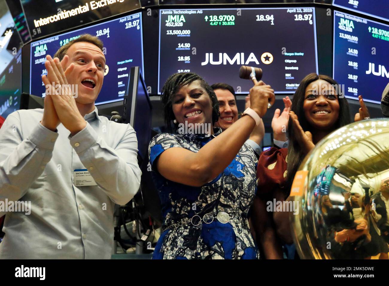 Jumia co CEO Sacha Poignonnec left applauds as Jumia Nigeria CEO Juliet Anammah center rings a ceremonial bell when the company s stock begins trading on the floor of the New York Stock Exchange