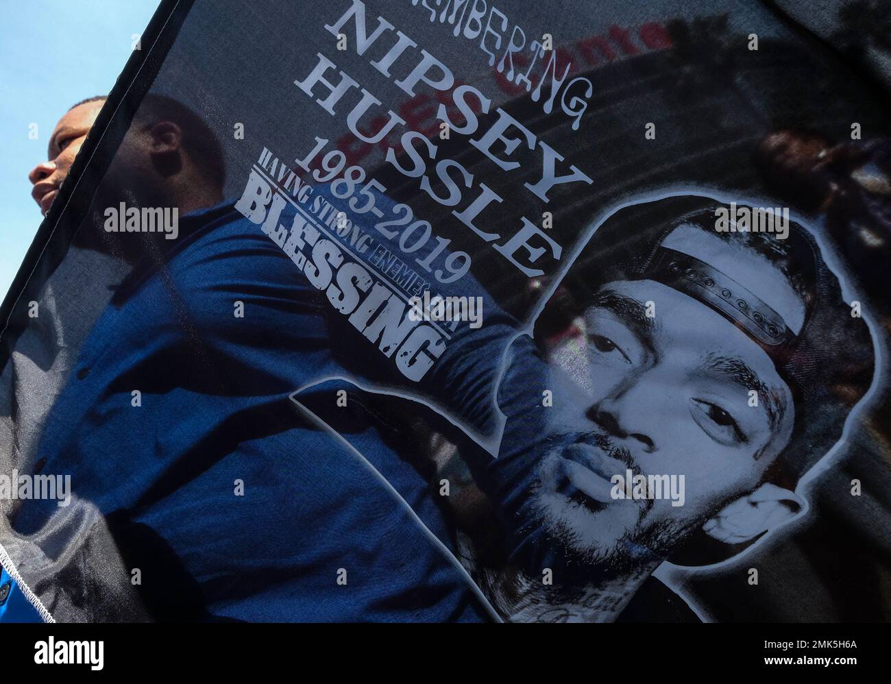 A fan of rapper Nipsey Hussle holds a sign as he attends a public