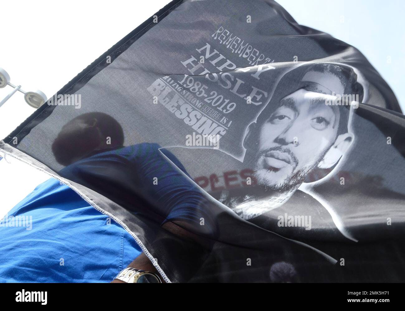 A fan of rapper Nipsey Hussle holds a sign as he attends a public