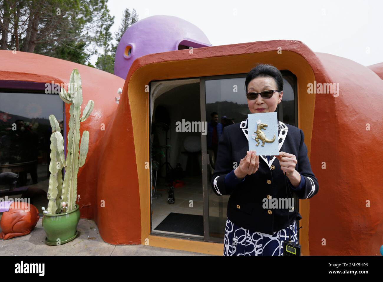 Florence Fang holds up a card with a dinosaur on it that she plans to