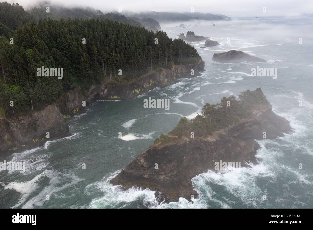 Fog drifts over the beautiful coastline of southern Oregon near Brookings. This part of the Pacific Northwest is known for its outdoor scenery. Stock Photo
