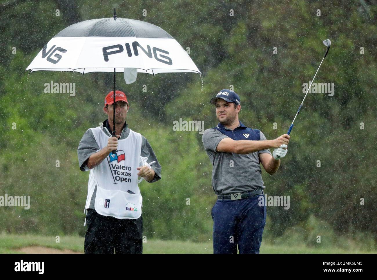 Corey Conners, right, hits an approach shot on the second hole during ...
