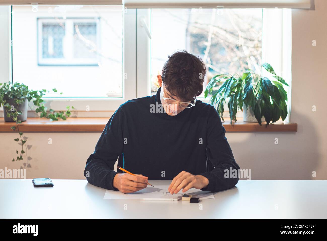 Brown-haired young architect creates new product designs for a new ...