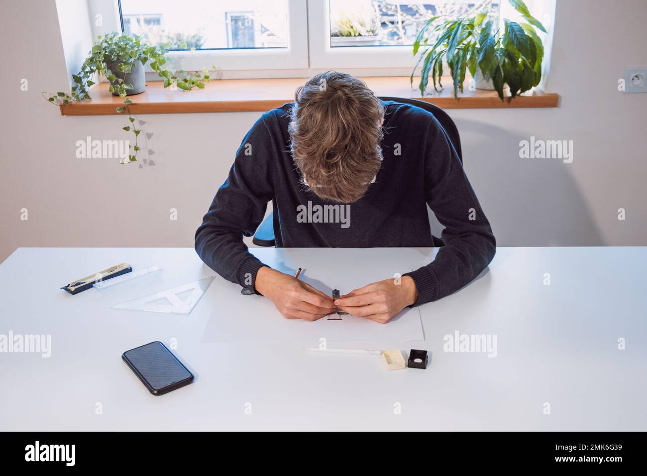Brown-haired young architect creates new product designs for a new ...