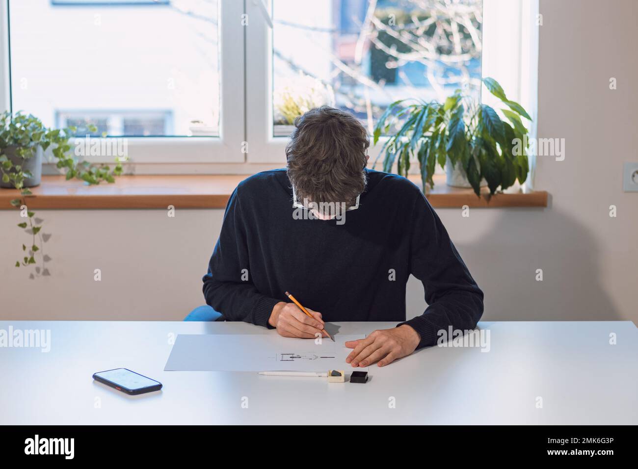 Brown-haired young architect creates new product designs for a new ...