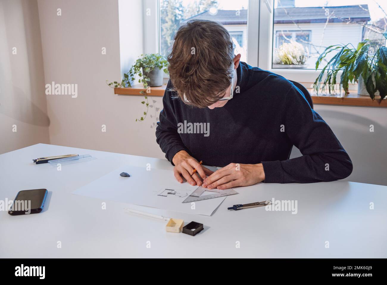 Brown-haired young architect creates new product designs for a new ...